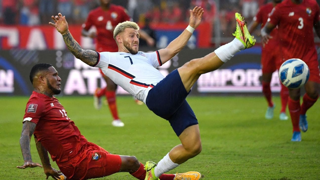 USMNT player in white jersey number 7 attempts acrobatic kick while Panama defender in red slides to challenge during World Cup qualifier