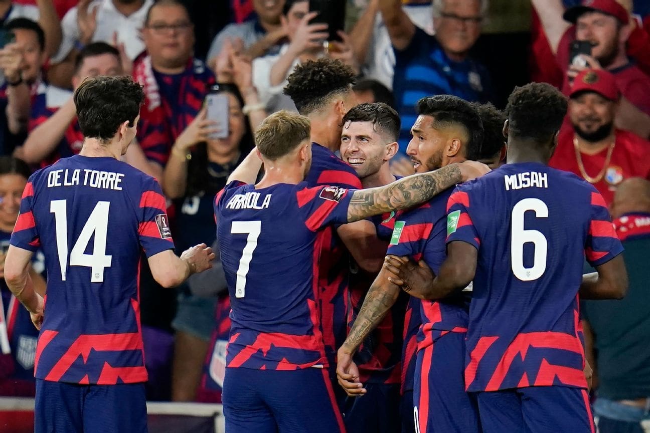 Christian Pulisic celebrates hat trick goal with USMNT teammates in navy blue jerseys during World Cup qualifier against Panama