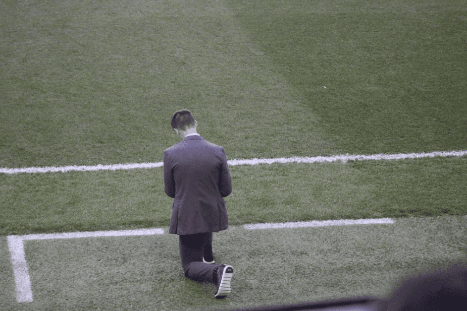 New York Red Bulls Head Coach Troy Lesessne takes a knee prior to the opening kickoff to pray before the match. 