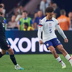 Robinson of the U.S. Men's National team playing a ball under pressure by Canada.
