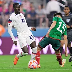 Tim Weah Dribbles past Israel Reyes of Mexico