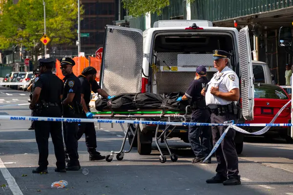 NYPD assisting medical examiner office place bodies in van for Morgue. 