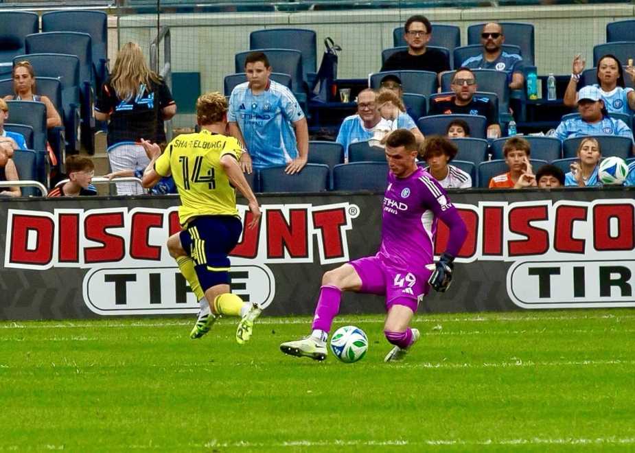 Matt Freese number 49 New York City FC goalkeeper makes diving save against Jacob Shaffelburg number 14 Nashville SC