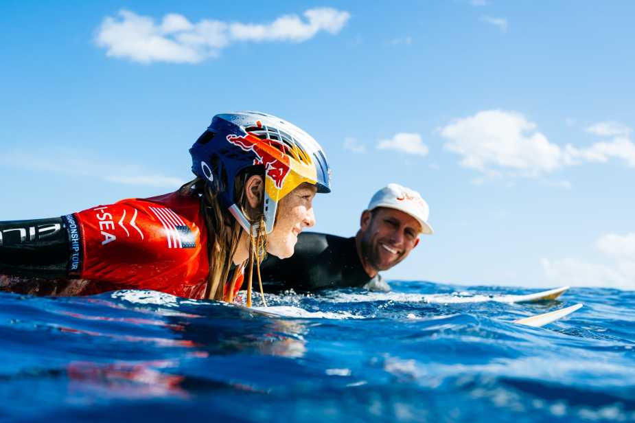 Caitlin Simmers smiling in water wearing Red Bull helmet at Lexus Tahiti Pro