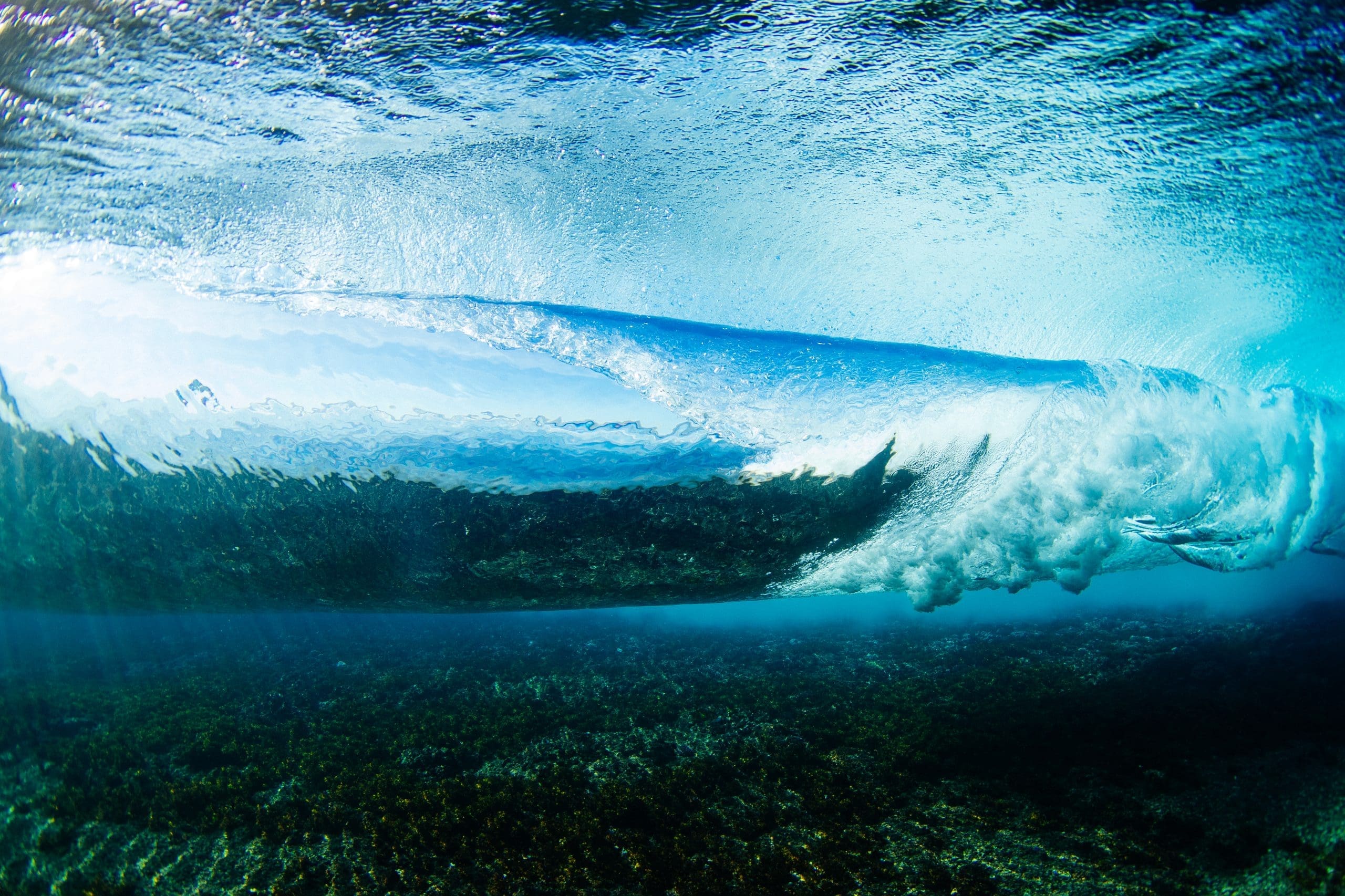Underwater view of perfect barrel wave breaking over coral reef at Cloudbreak Fiji during 2025 WSL Finals