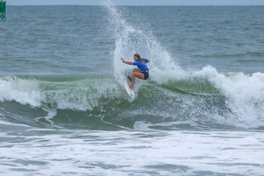 Lilie Kulber performs a dynamic top turn with explosive spray during her quarterfinal heat at the 2025 Virginia Beach Pro surfing competition
