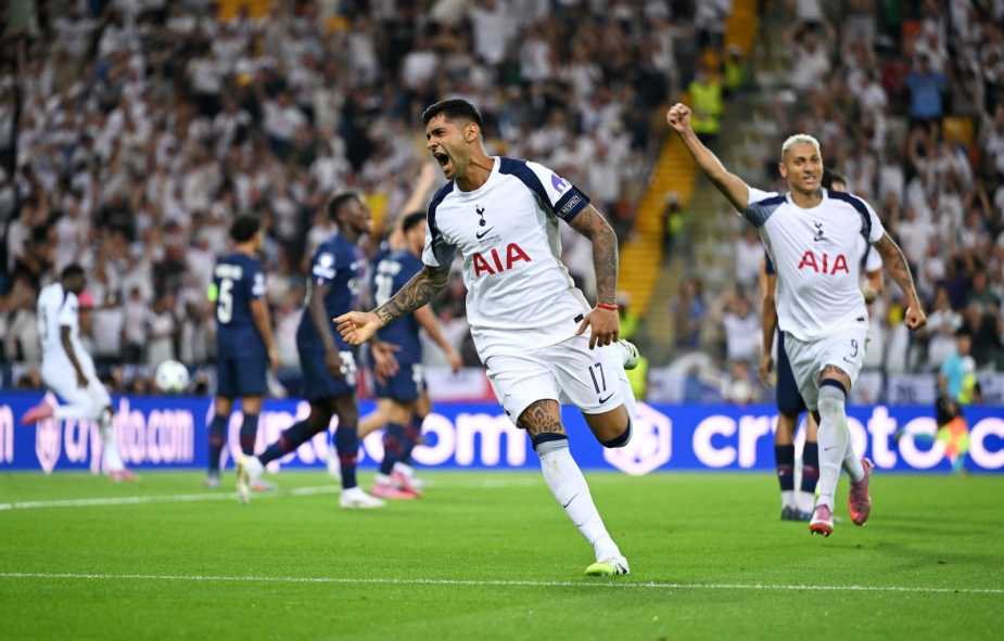 A Tottenham Hotspur player celebrates after scoring a goal during the UEFA Super Cup match against Paris Saint-Germain, with teammates and cheering fans in the background.