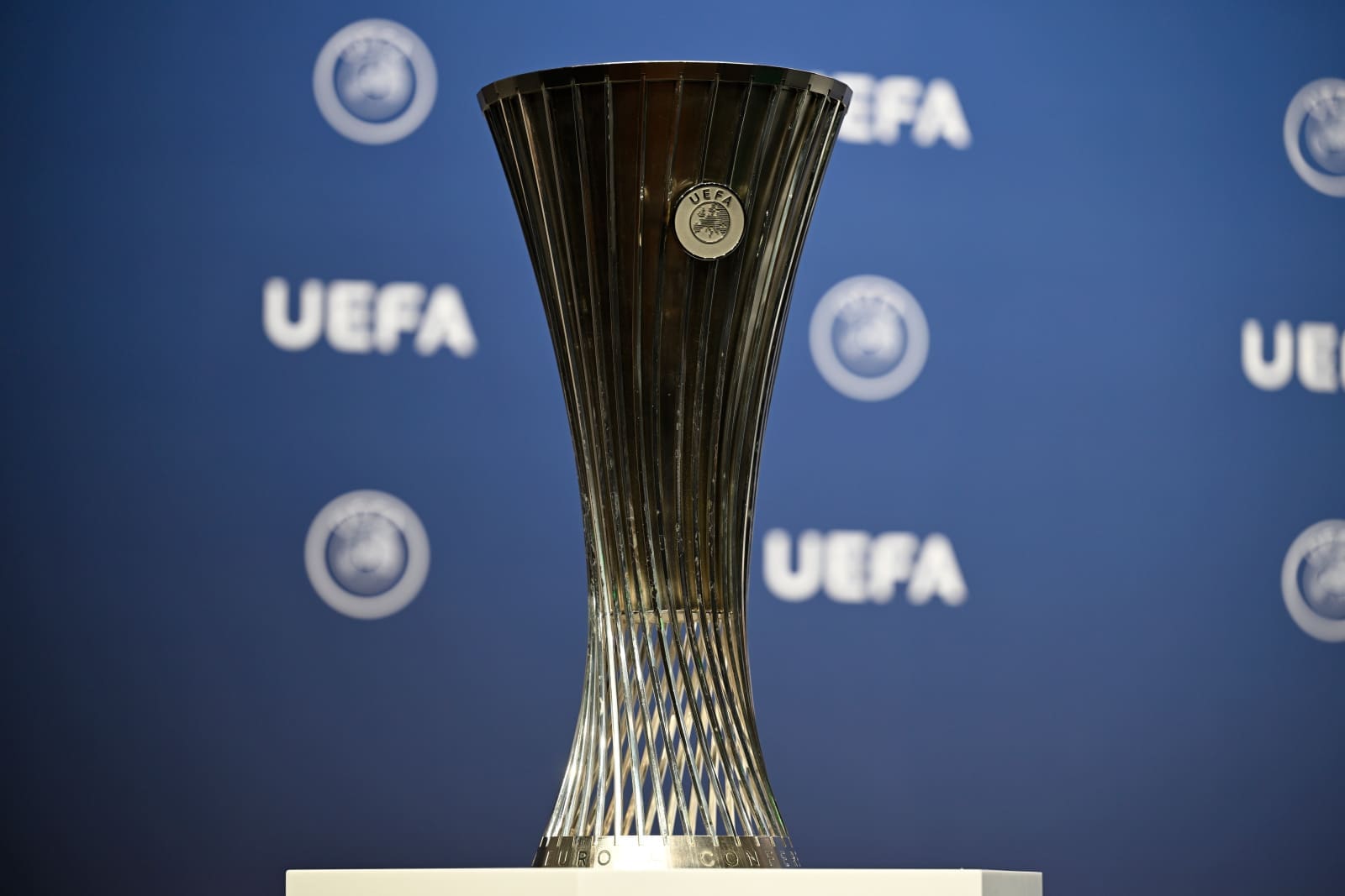 UEFA Conference League trophy displayed against blue UEFA branded backdrop during 2025/26 third qualifying round draw ceremony