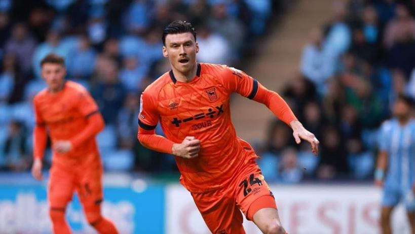Kieffer Moore in orange jersey running during Championship match for Ipswich Town