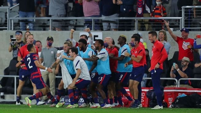 USMNT players and coaching staff celebrate together on sideline after scoring comeback goal against Costa Rica in World Cup qualifier