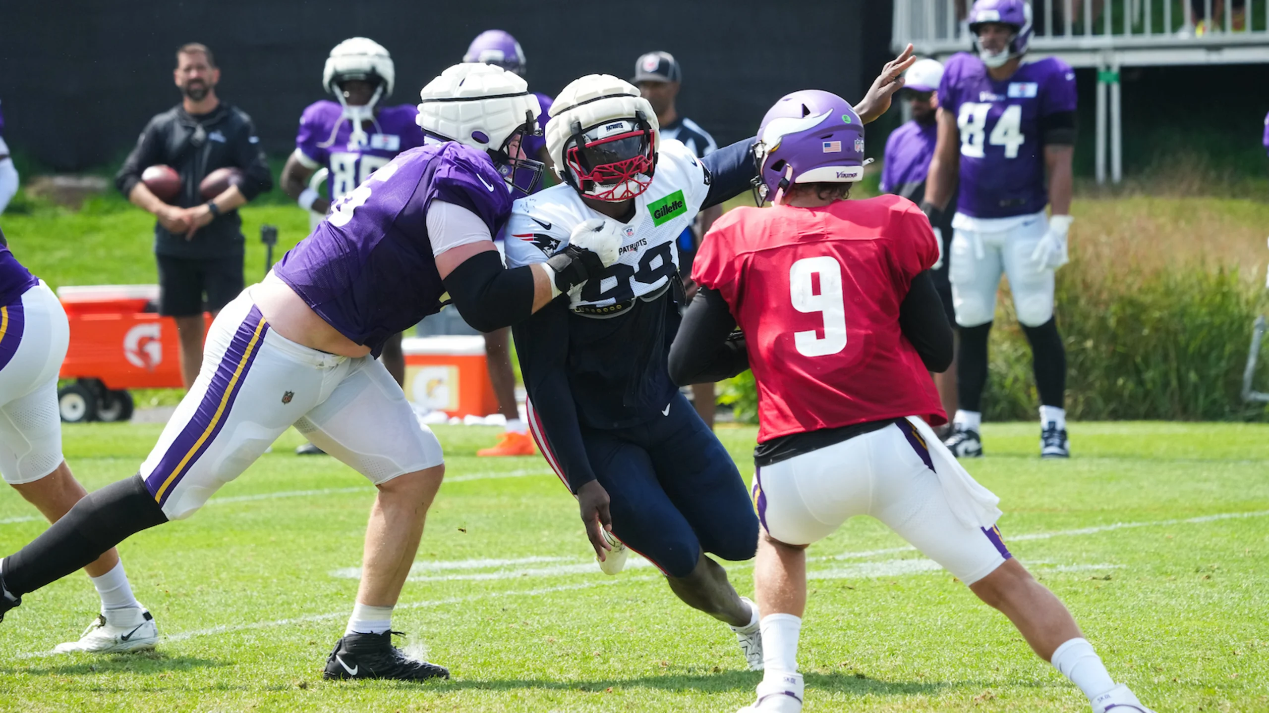 Patriots defensive player rushes through Vikings offensive line during joint practice drill in Minnesota