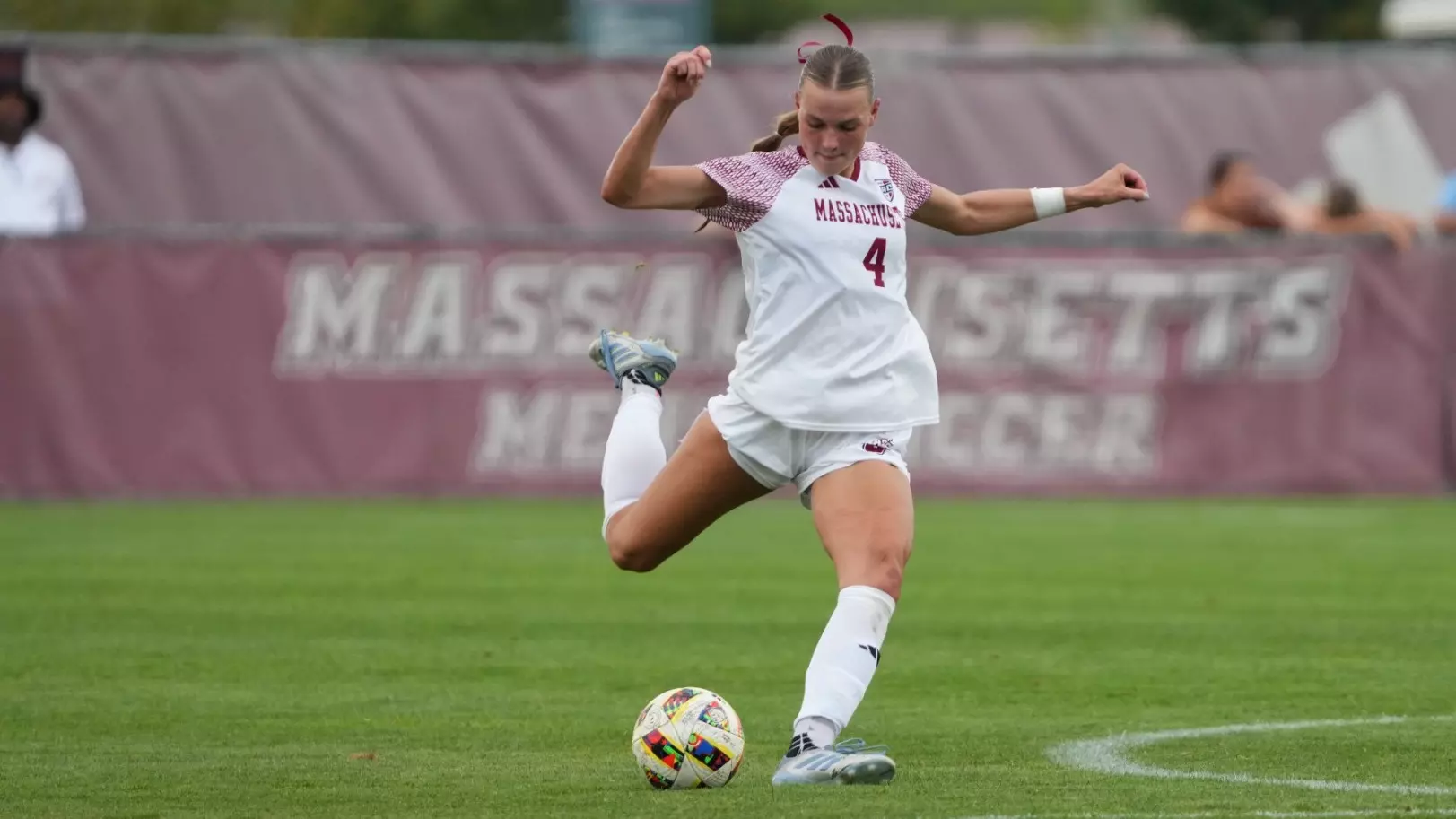 UMass Amherst women's soccer player Amelia Deren in action during a match, wearing the Minutewomen uniform while controlling the ball on the field