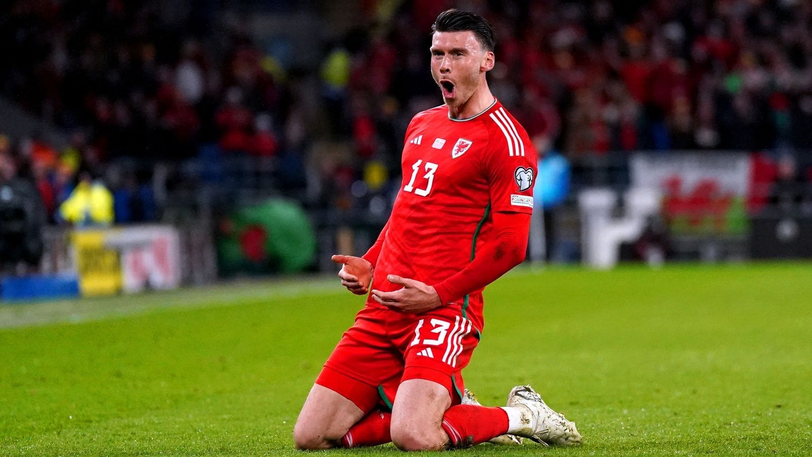 Kieffer Moore celebrates in Wales red jersey number 13 during international match