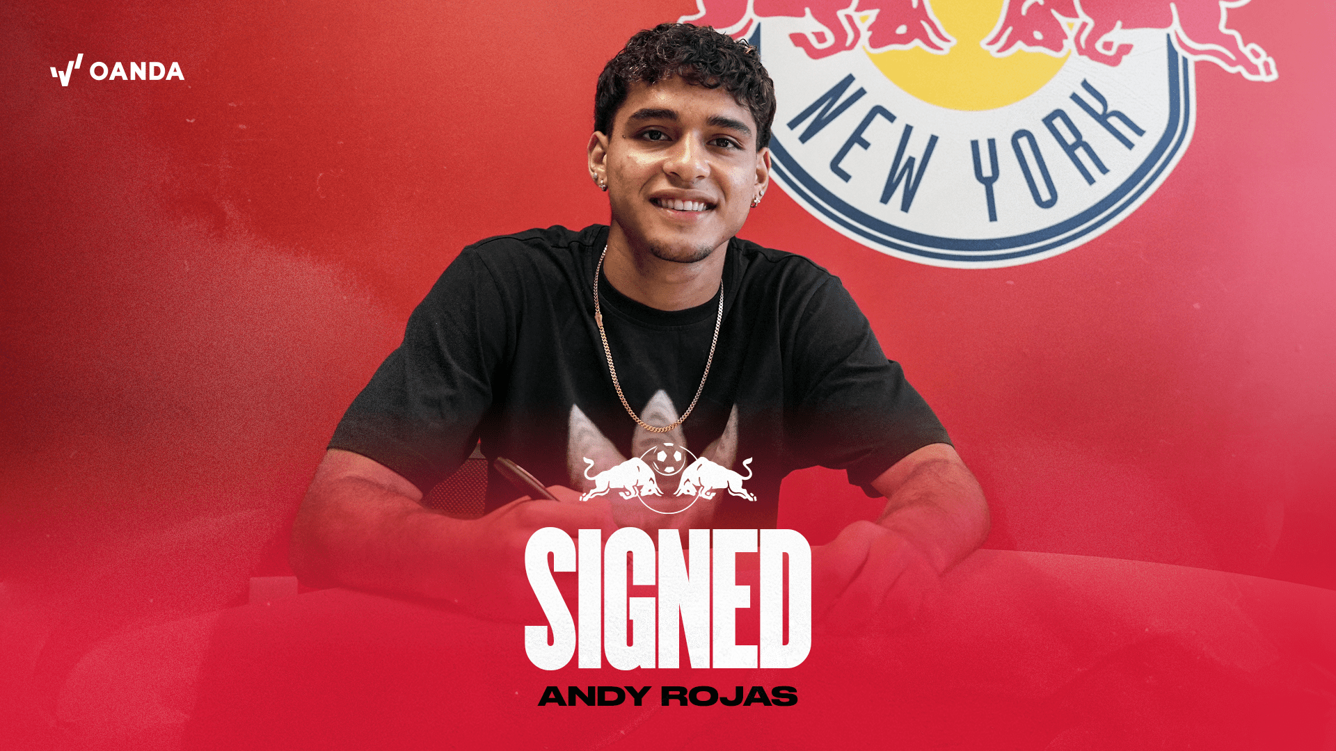 Andy Rojas smiles while holding New York Red Bulls jersey after completing transfer signing