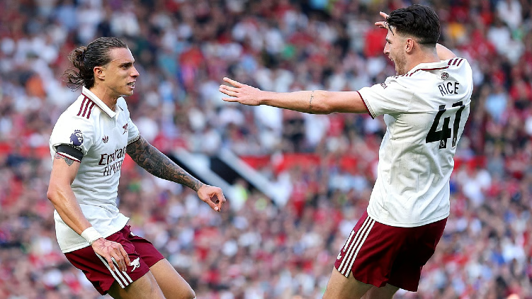 Arsenal players including Declan Rice celebrate during Premier League match at packed stadium with fans in background