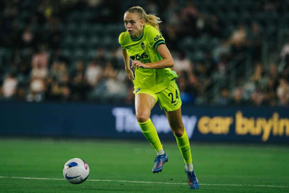 Esme Morgan #24 of Washington Spirit in yellow away kit dribbles forward with the ball during match against Angel City FC, showing focused determination