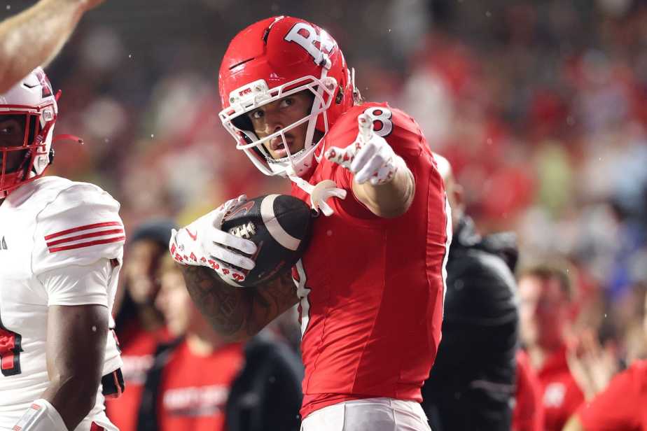 Rutgers wide receiver KJ Duff in red jersey celebrates a first down by raising his finger while securely holding the football after making a catch