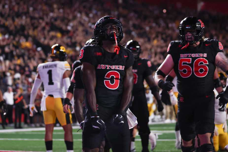 Rutgers running back Antwan Raymond, number 3, celebrates a touchdown in the end zone with offensive lineman Tyler Needham, number 56, while Iowa defenders look on in disappointment