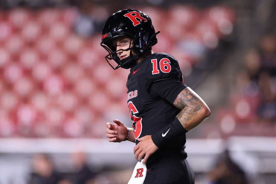 Rutgers quarterback Athan Kaliakmanis, wearing number 16 in black uniform with red "R" helmet, stands ready during the Big Ten conference game against Iowa