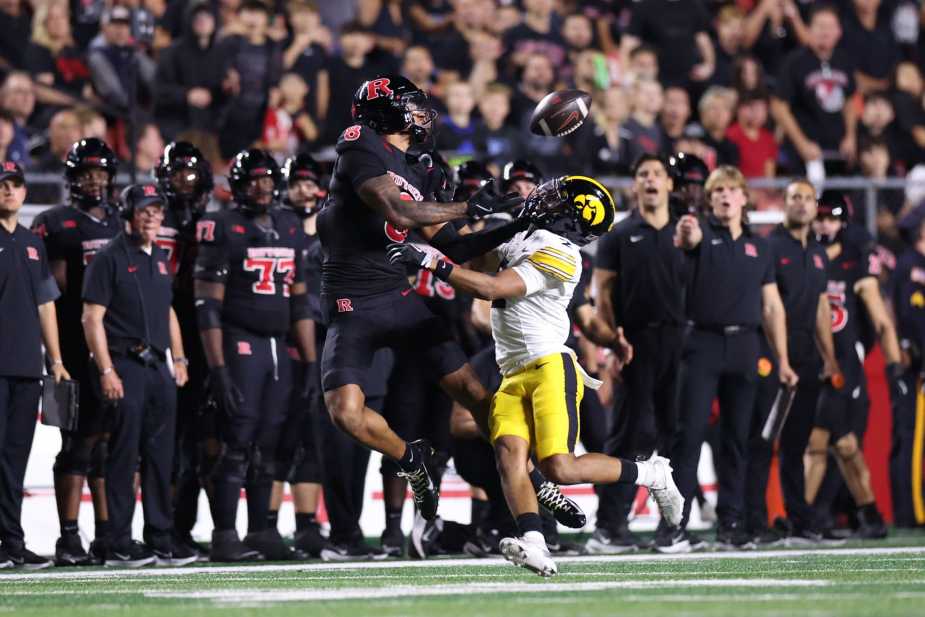 Rutgers wide receiver #8 KJ Duff leaps to catch a football while battling with an Iowa defender in a high-intensity sideline play during the Big Ten conference game