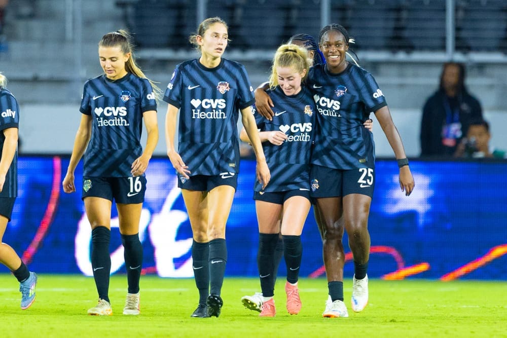Washington Spirit players Courtney Brown, Paige Metayer, Heather Stainbrook and Kysha Sylla celebrate together in their navy blue CVS Health jerseys during the 4-0 Concacaf W Champions Cup victory over Vancouver Rise FC Academy