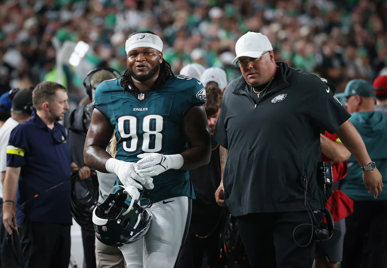 Philadelphia Eagles player Jalen Carter being escorted to the locker room by Eagles Head of Security "Big Dom" after the player spat on Dax Prescott of the Dallas Cowboys in pre-game.