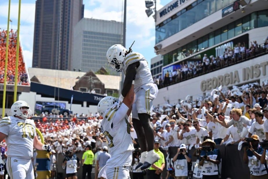 Georgia Tech offensive lineman lifts a wide receiver in celebration in the end zone during a touchdown celebration against #12 Clemson