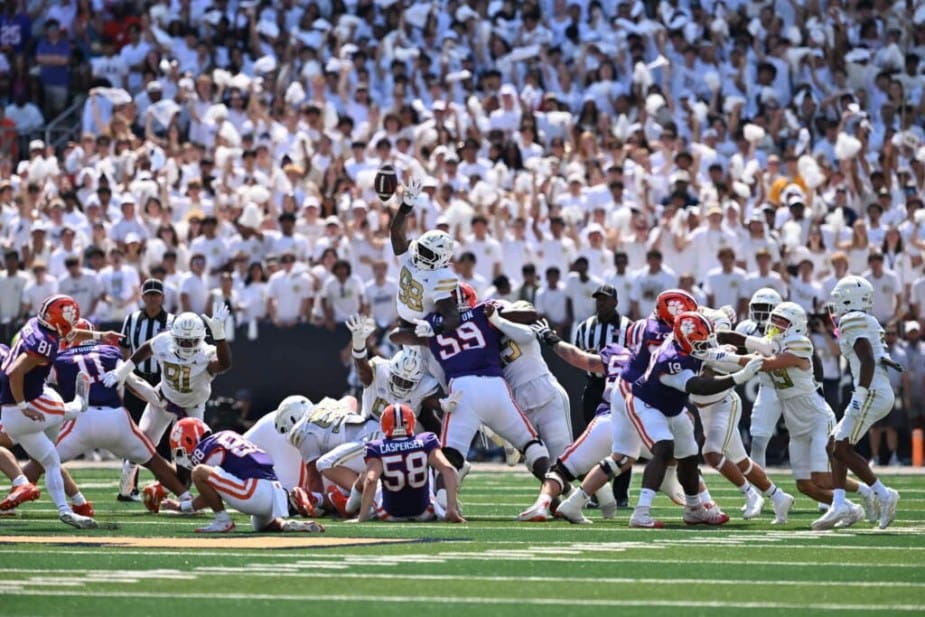 Georgia Tech defensive lineman Amontrae Bradford (#98) leaps with arms extended, nearly blocking a field goal attempt by #12 Clemson