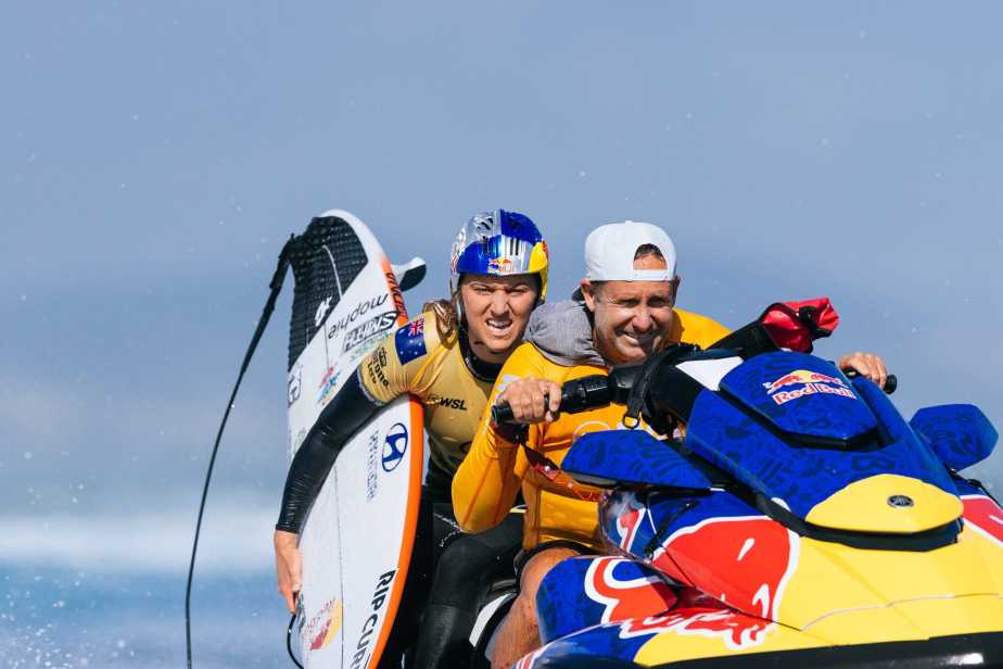 Molly Picklum with her team on a Red Bull Branded ski jet, wearing her Red Bull helmet and yellow WSL jersey, celebrating her World Championship