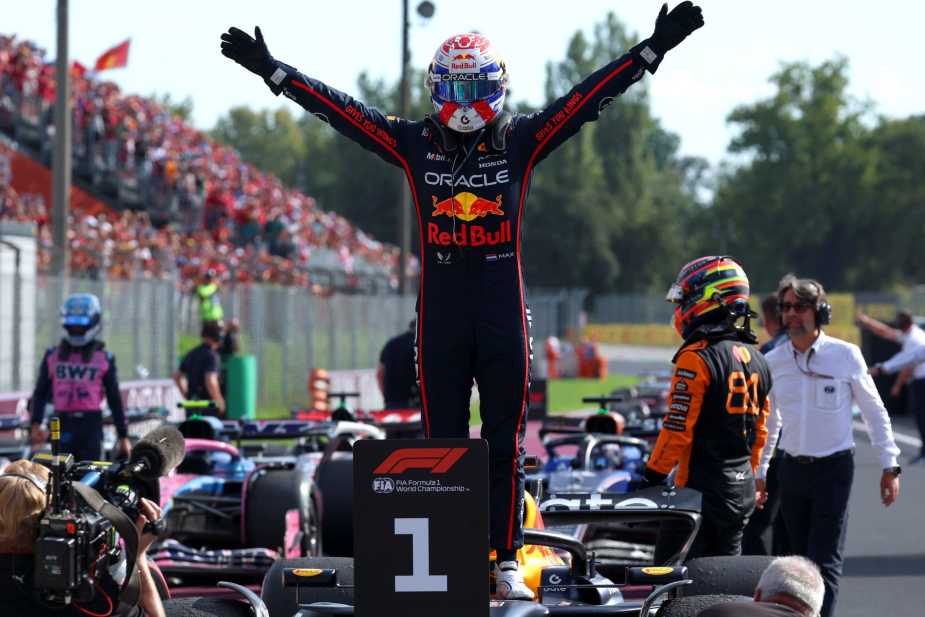 Max Verstappen celebrates victory with arms raised while standing on his Red Bull F1 car after winning the Italian Grand Prix at Monza