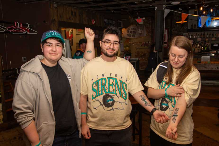 Three New York Sirens fans displaying team temporary tattoos on their arms