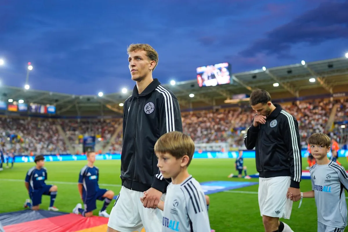 Germany U-21 national team players walking out with child mascots before the match, wearing their official team uniforms, lined up in a formal pre-game procession