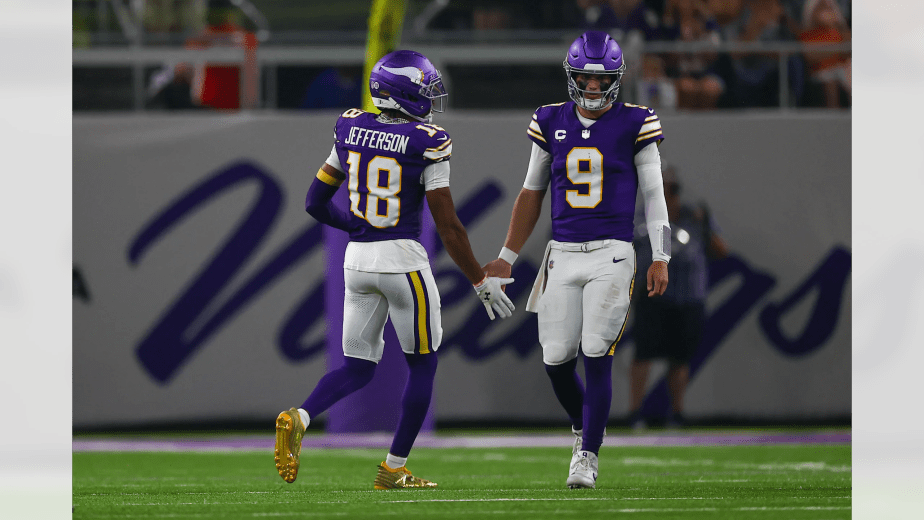 Minnesota Vikings wide receiver Justin Jefferson #18 gives a low five to quarterback J.J. McCarthy during the team's Week 2 Sunday Night Football game against the Atlanta Falcons at U.S. Bank Stadium