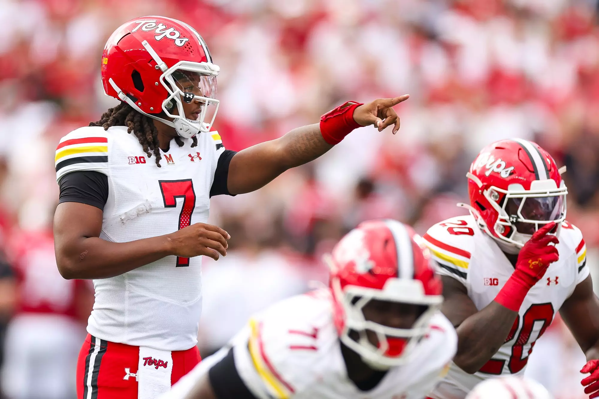 Maryland Terrapins quarterback Malik Washington (#7) points and calls out defensive adjustments at the line of scrimmage during a Big Ten conference game against the Wisconsin Badgers at Camp Randall Stadium