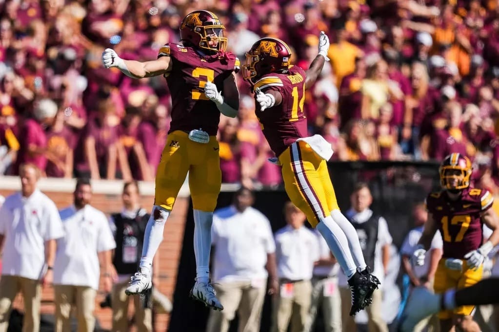 University of Minnesota Gophers players Koi Perich and Kerry Brown celebrating touchdown with arms raised in maroon and gold uniforms