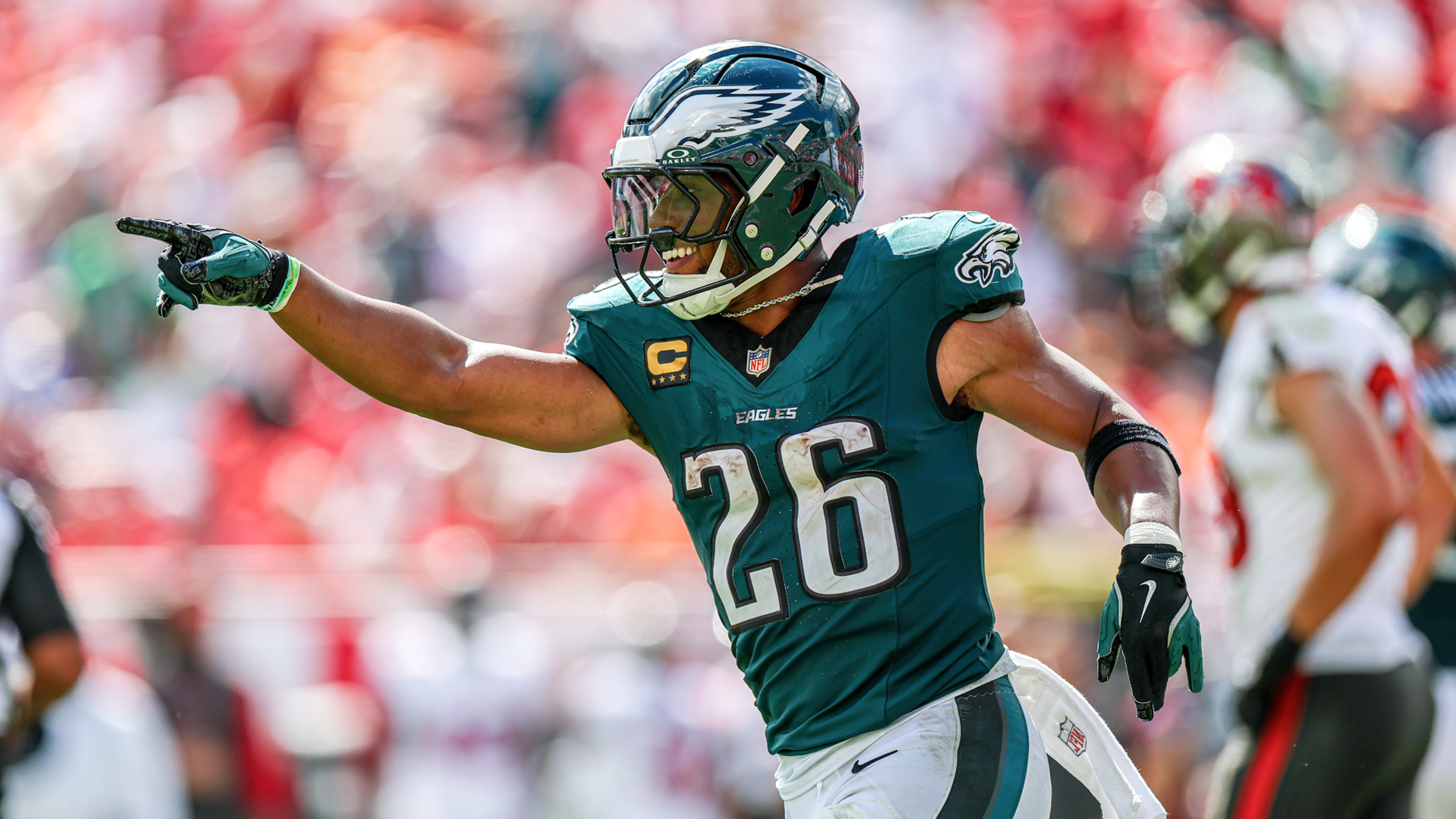 Philadelphia Eagles running back Saquon Barkley celebrates first down with arms outstretched in midnight green uniform