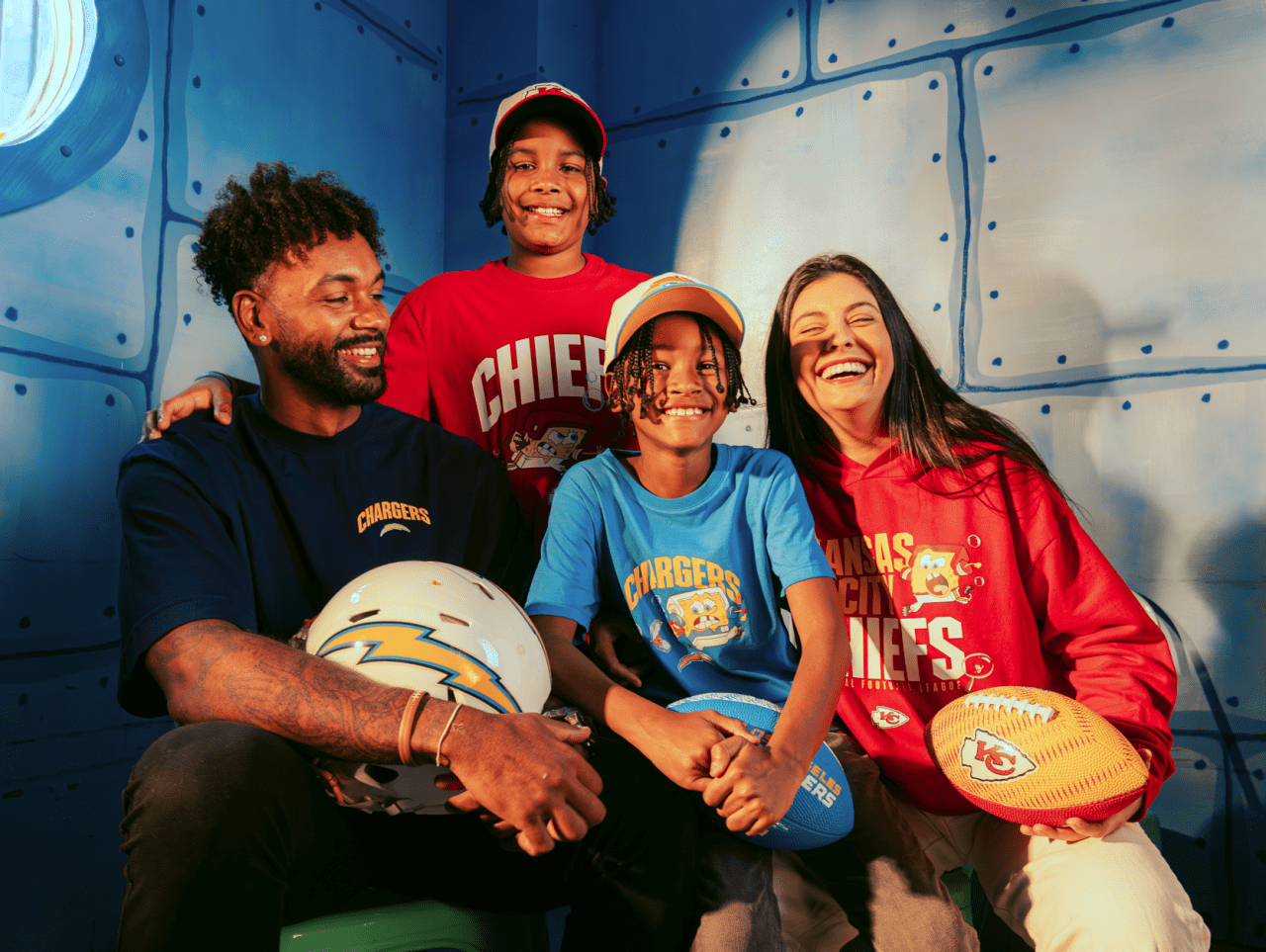 Family wearing NFL team jerseys featuring SpongeBob SquarePants designs posing together in underwater-themed setting with footballs