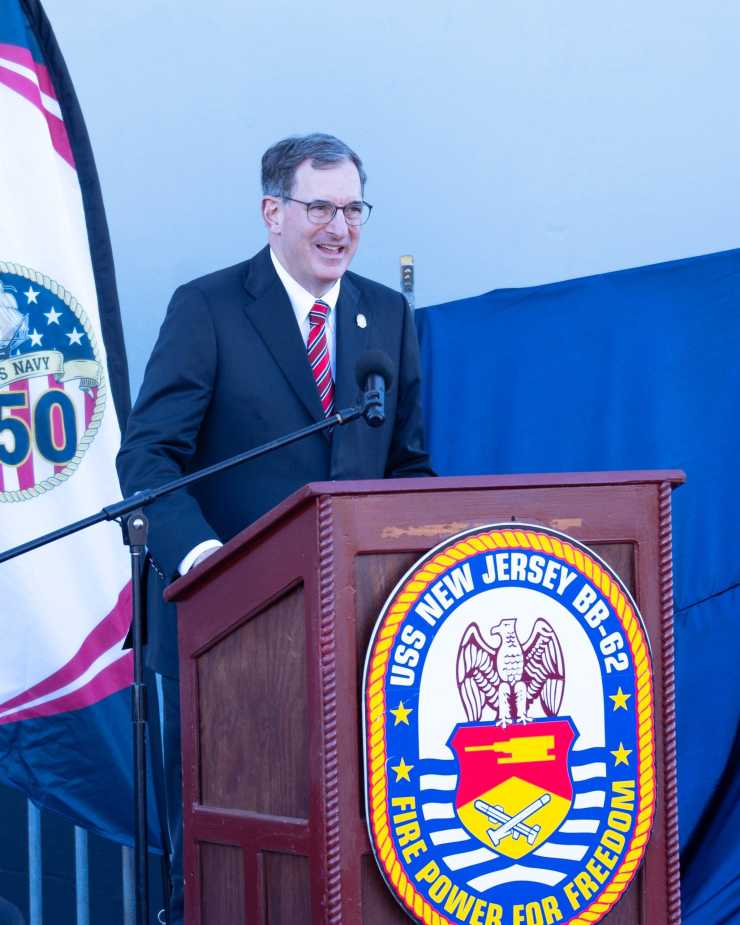 George Leon, President and Chair of Homecoming 250 and Battleship New Jersey trustee, speaks at USS Enterprise stern plate unveiling ceremony during Navy 250th anniversary celebration on October 10, 2025.