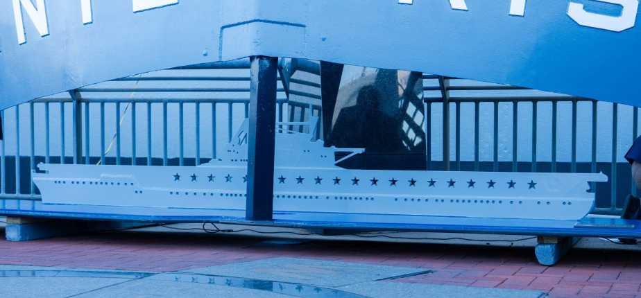 Scale model silhouette of USS Enterprise (CV-6) displaying 20 battle stars earned during World War II, exhibited at Battleship New Jersey Museum during Navy 250th anniversary celebration on October 10, 2025.