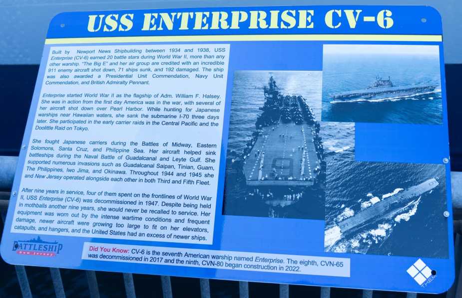 Educational plaque titled "USS Enterprise CV-6" detailing the aircraft carrier's World War II service, 20 battle stars, combat achievements, and historical photographs at Battleship New Jersey Museum during Navy 250th anniversary celebration.