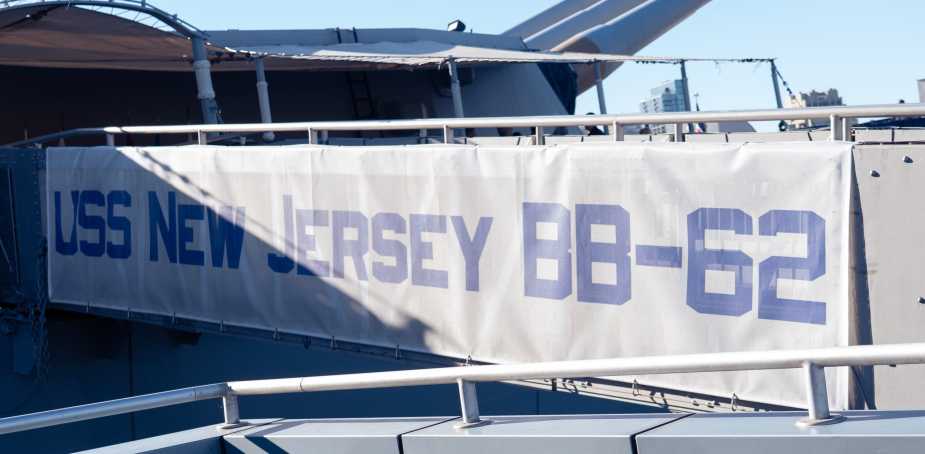 USS New Jersey BB-62 boarding bridge banner displaying ship name and hull number at Battleship New Jersey Museum and Memorial in Camden, NJ, during Navy 250th anniversary celebration.
