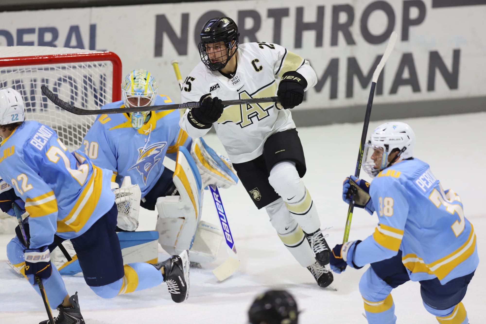 Army Black Knights captain Barron Woodring screens LIU goaltender Daniel Duris, number 30, while looking for a deflection in front of the net during an exhibition game at Tate Rink