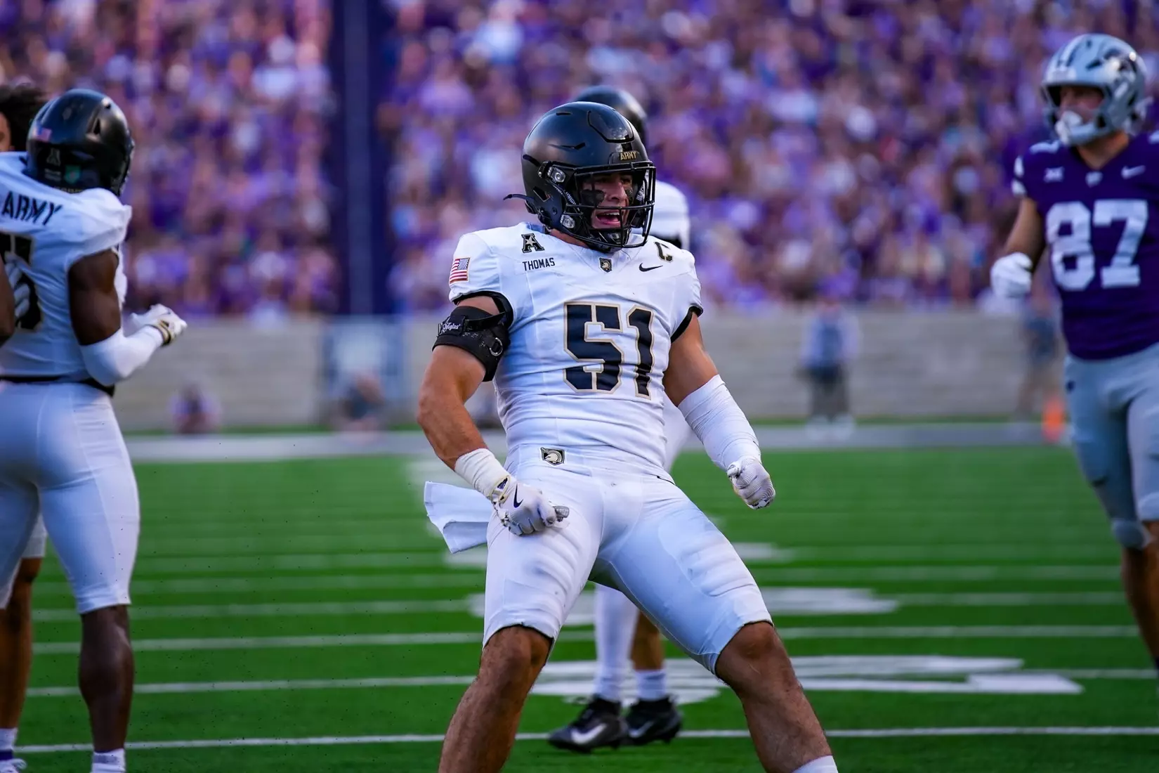 Army West Point linebacker Andon Thomas celebrates in his white Black Knights football uniform during a game