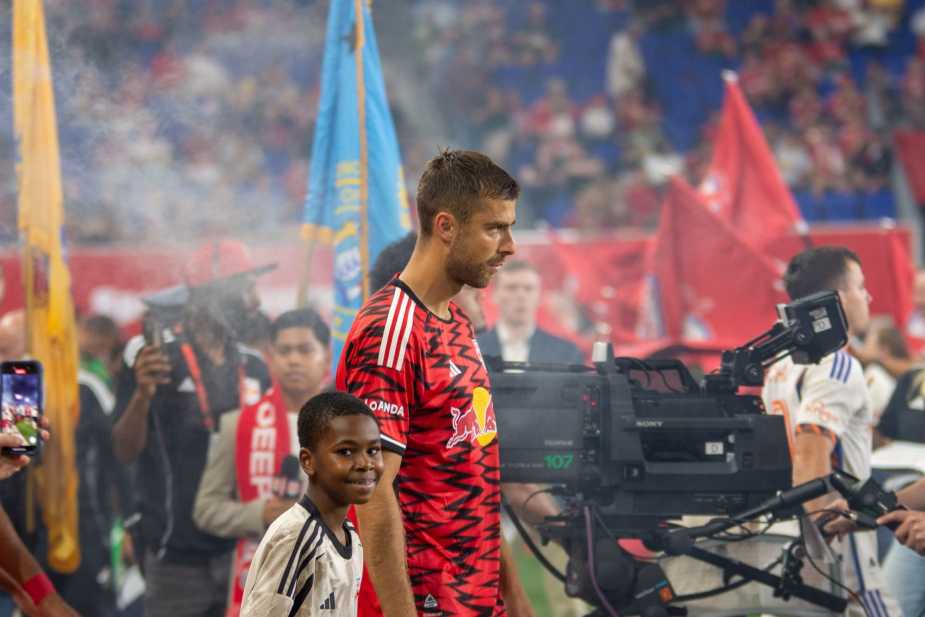 New York Red Bulls center-back Alexander Hack walks onto the field with a young mascot during pre-match ceremonies before facing FC Cincinnati at Sports Illustrated Stadium on October 4, 2025