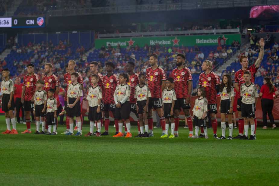 New York Red Bulls starting eleven and mascots line up on the field during the national anthem before their match against FC Cincinnati at Sports Illustrated Stadium on October 4, 2025