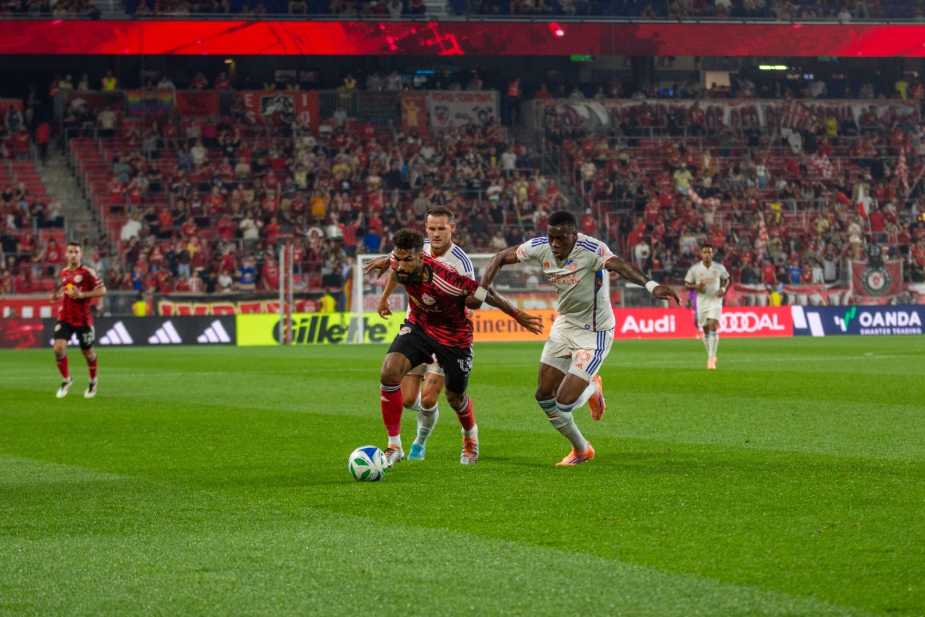 New York Red Bulls forward Eric Maxim Choupo-Moting sprints past two FC Cincinnati defenders with arms outstretched during the Red Bulls' 0-1 loss at Sports Illustrated Stadium on October 4, 2025