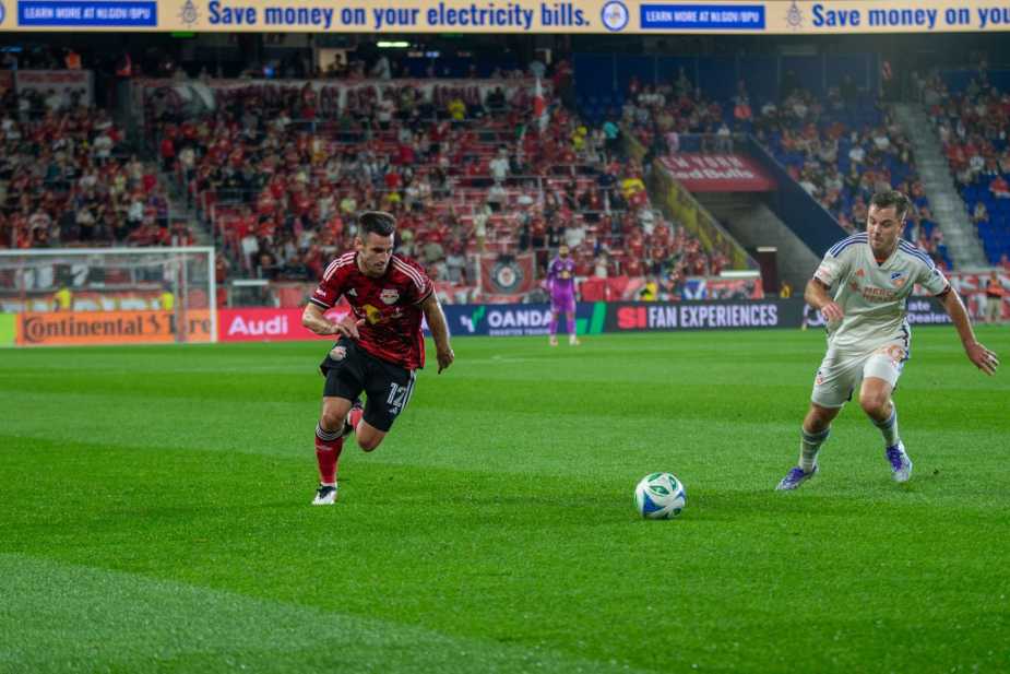 New York Red Bulls defender Dylan Nealis dribbles down the sideline while being pursued by an FC Cincinnati defender during the Red Bulls' 0-1 loss at Sports Illustrated Stadium on October 4, 2025