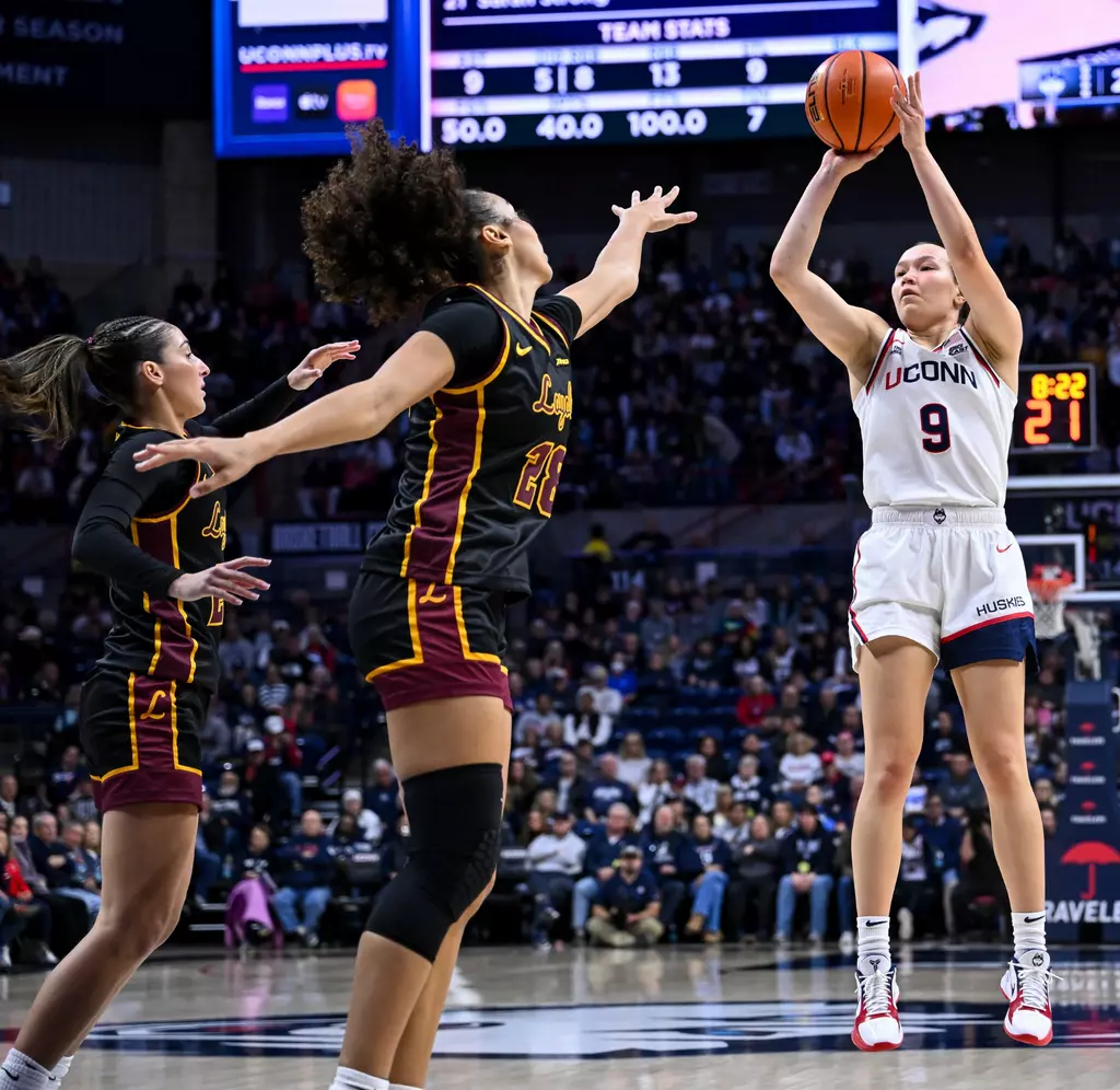 Kayleigh Heckel number 9 of UConn Huskies women's basketball drives against Loyola Chicago Ramblers at Gampel Pavilion