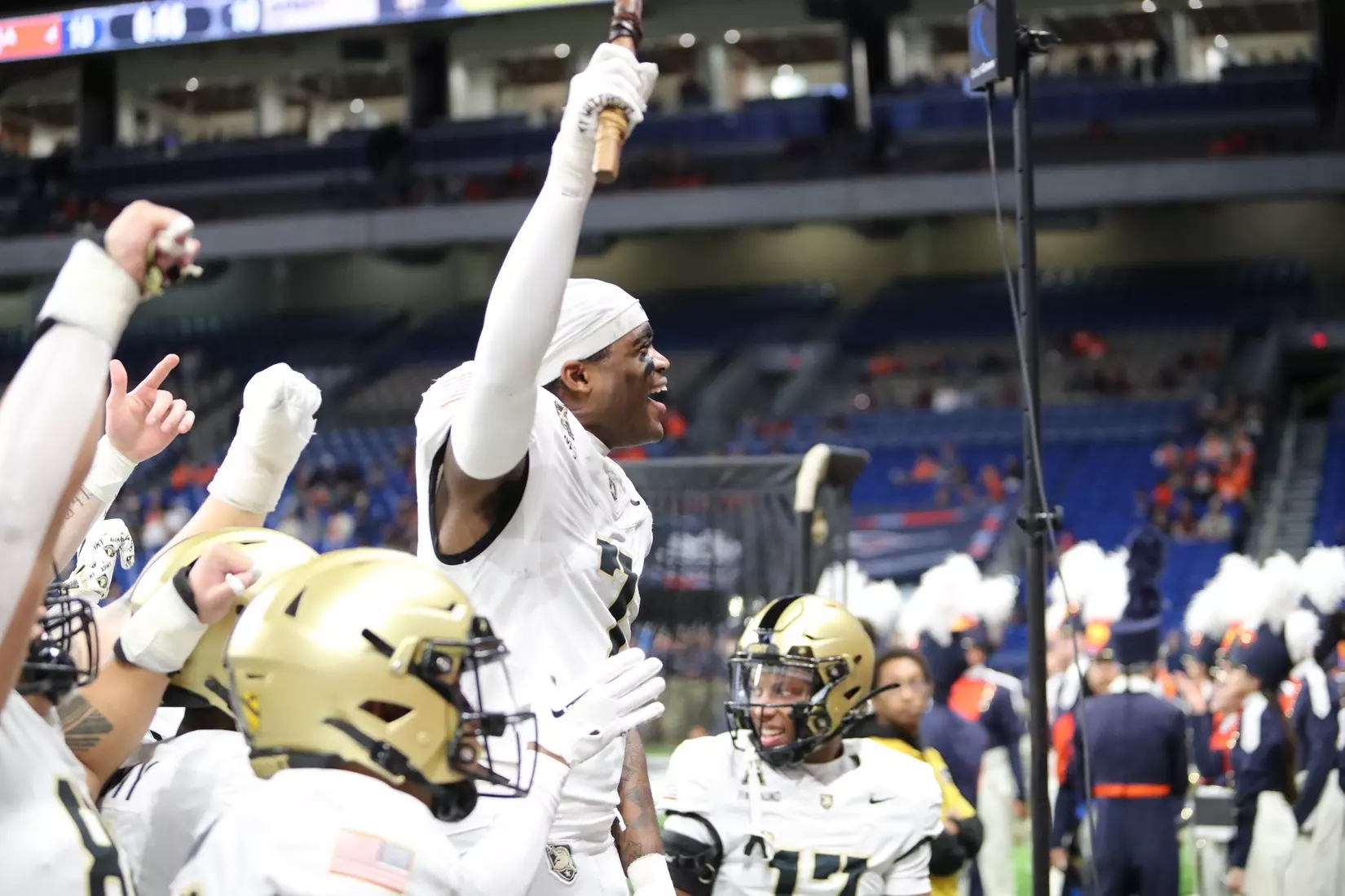 Army Black Knights junior cornerback Jaydan Mayes celebrates with arms raised high as teammates lift him up in celebration after his game-changing 73-yard interception return for touchdown against UTSA