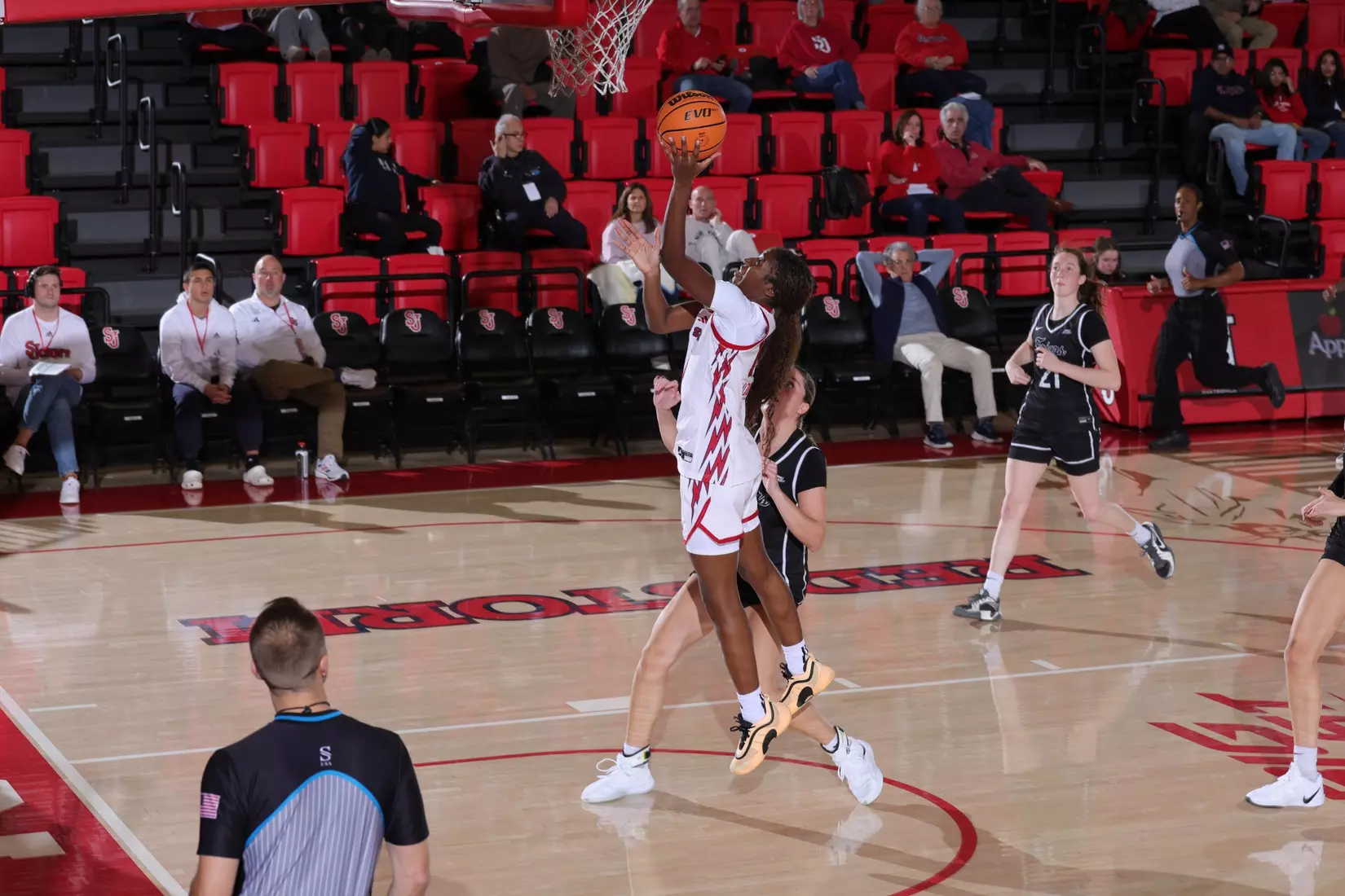 St. John’s women’s basketball player drives to the basket for a layup against Providence.